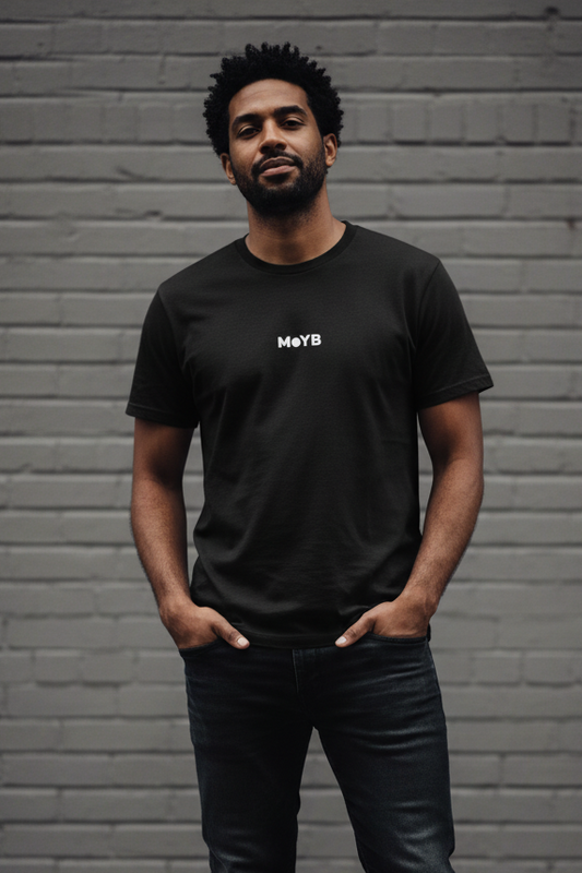 Mixed race man in MoYB Everyday Tee Black against grey brick wall